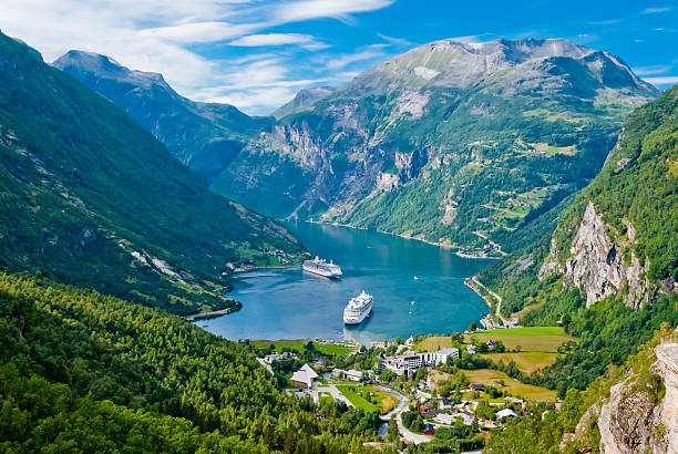 A ship sailing between towering cliffs in a Norwegian Fjord
